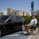 Pessoa com deficiência em estacionamento em frente a carro com isenção PcD