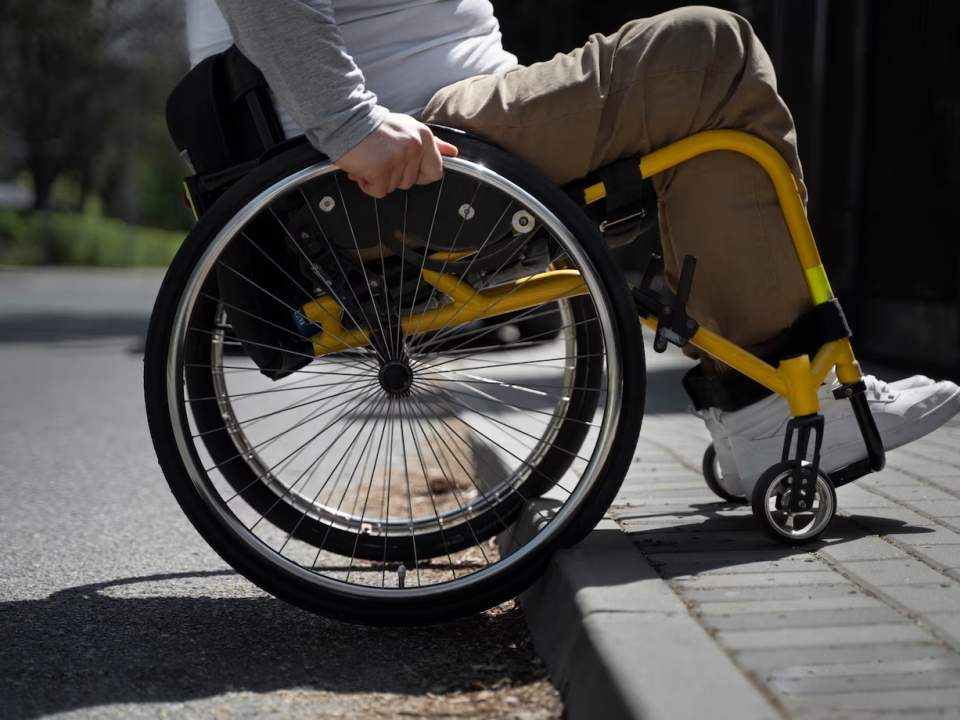 Pessoa com deficência tentando subir em calçada sem rampa de acessibilidade